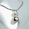 White gold green pearl pendant with diamond from GoldQuestJewelers jewelry store in Boston MA